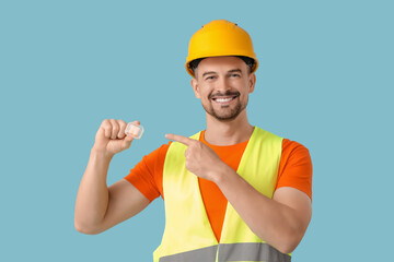Male builder with earplugs on blue background