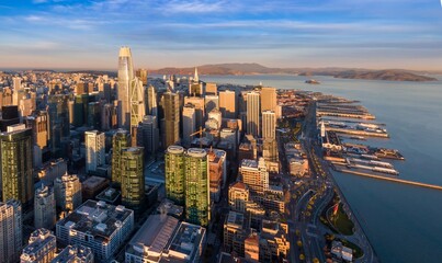 Aerial view of San Francisco, California, USA, showcasing the city skyline, waterfront, and the iconic Golden Gate Bridge in the background during a sunny day.