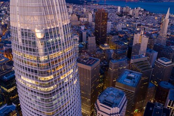 Aerial view of the illuminated San Francisco skyline at dusk, showcasing the Salesforce Tower and...