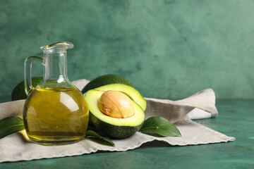Jug of avocado oil on green background