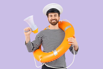 Male sailor with rescue ring and megaphone on lilac background