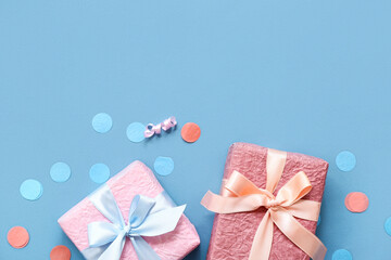 Gift boxes with serpentine and confetti on blue background