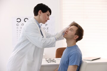 Fototapeta premium Professional ophthalmologist examining patient's vision in clinic