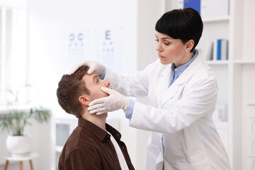 Obraz premium Professional ophthalmologist examining patient's vision in clinic