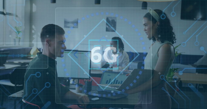 Three professionals analyzing digital 6G overlay in office, holding laptop and pointing at monitor