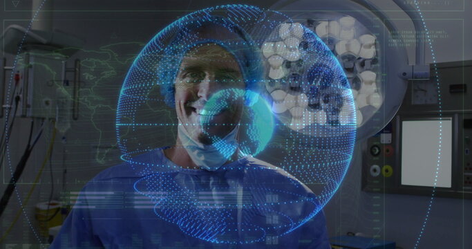 Standing surgeon wearing scrubs cap and mask in operating room, examining digital globe hologram