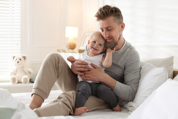 Obraz premium Bedtime. Happy father with his cute little baby on bed at home