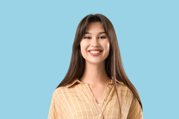 Young woman with beautiful smile on blue background