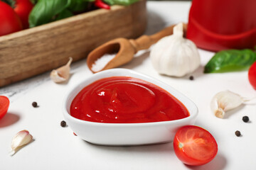 Bowl of tasty ketchup with garlic and peppercorns on white background, closeup