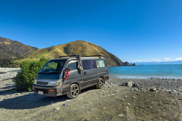 New Zealand. Tourists' campervan at Cable Bay, Nelson Region. Tranquil South Island beach. Bikini...