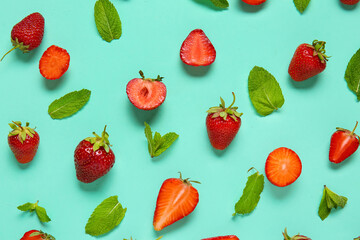 Fresh ripe strawberries and mint leaves on turquoise background