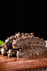 Raw sea cucumber trepang on wooden table.