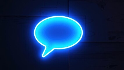 Glowing blue neon speech bubble sign on a dark wall suggesting communication