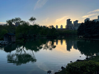 Lake park view and behind modern buildings silhouette at sunset in Istanbul, Turkey.