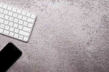 Smartphone and Wireless Keyboard on Textured Gray Surface