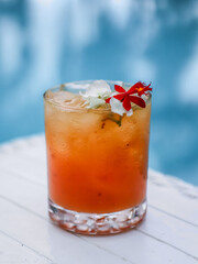 Refreshing cocktail with ice and flowers by the pool