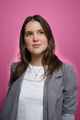 Confident young woman in modern studio portrait with pink background