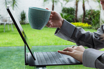 Young woman working remotely with tablet and smartphone outdoors