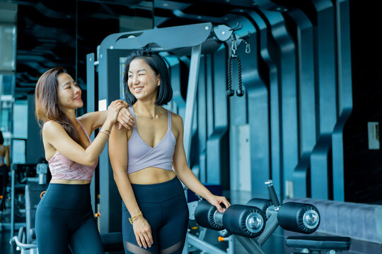 Multiethnic group young fitness women training at the gym. Athletic women doing stretches and warming up before workout.
