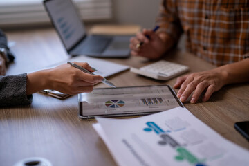 A man is pointing at a tablet with a pie chart on it