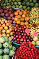 Colorful tropical fruits stacked at a Bali market—mangoes, bananas, strawberries, passion fruits, and guavas. Ideal for food, travel, and cultural themes.