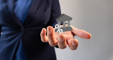 Businesswoman hand holding a 3D bank icon with percentage sign