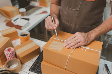 he is checking the boxes in the packing room, a small business owner is preparing boxes to ship to...