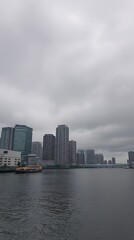 Fototapeta premium Gloomy city skyline from across water
