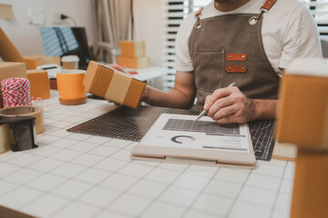 he is checking the boxes in the packing room, a small business owner is preparing boxes to ship to...