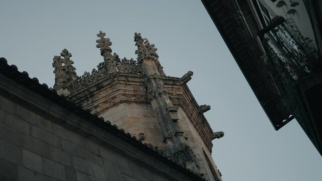 ornate church tower rises in old braga viewed between close stone buildings