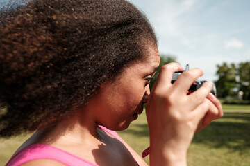 Young photographer concentrating while taking photos in a park