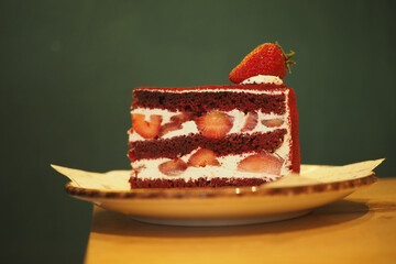 Red velvet cake slice with strawberries on a plate