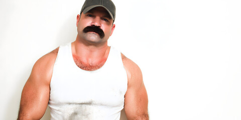 Muscular Man with Stache: A striking image captures a confident man with a prominent mustache and muscular build. Wearing a hat and a tank top against a clean backdrop. 