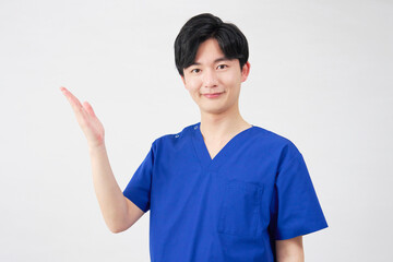 医者・看護師・歯科医師・介護士　左側を手のひらで指す男性　白背景