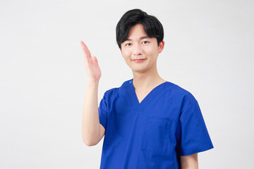 医者・看護師・歯科医師・介護士　左側を手のひらで指す男性　白背景