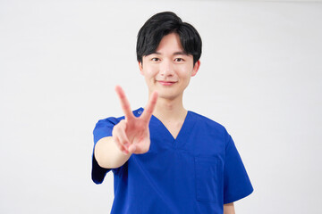 医者・看護師・歯科医師・介護士　男性　ピースサイン　白背景