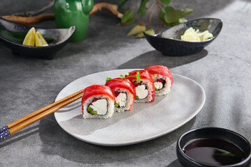 Tuna and avocado sushi roll, bright lighting, overhead composition on gray stone background