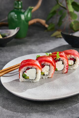 Tuna and avocado roll with creamy filling, bright lighting, overhead composition on gray ceramic plate