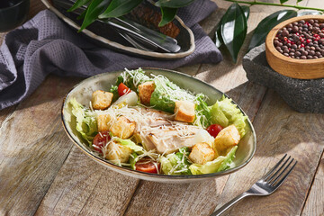Caesar salad with chicken fillet, bright natural light, overhead rustic wood composition