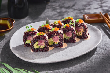 Wild rice maki sushi with tuna and avocado, bright moody lighting, overhead ceramic plate presentation