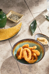 Tempura calamari rings in bright sunlight, overhead composition with ceramic accents
