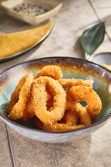 Tempura squid rings in ceramic bowl, bright lighting, overhead composition