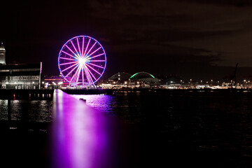 Obraz premium pink ferris wheel with reflection at night