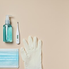 Protective Measures Against Infection: Hand Sanitizer, Thermometer, Gloves, and Mask on Beige Background