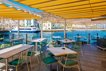 View from a seaside cafe overlooking the bay and marina at the picturesque whitewashed fishing village of Puerto de Mogán, Gran Canaria Island.