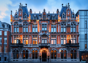 Fototapeta premium Historic red brick building under evening skies captured with a wide-angle lens