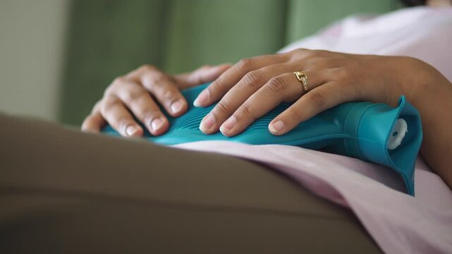 Relaxing on sofa with heating pad for discomfort relief