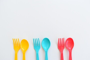 colorful spoon and fork isolated on white background, plastic cutlery for picnic