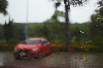 red car on parking in raining day, abstract blur background