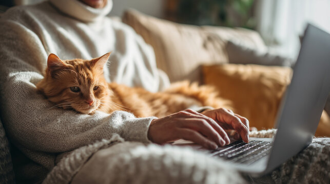 A man works from home, typing on a laptop with a cat beside him. Captures comfort, productivity, and companionship in a relaxed remote work environment.